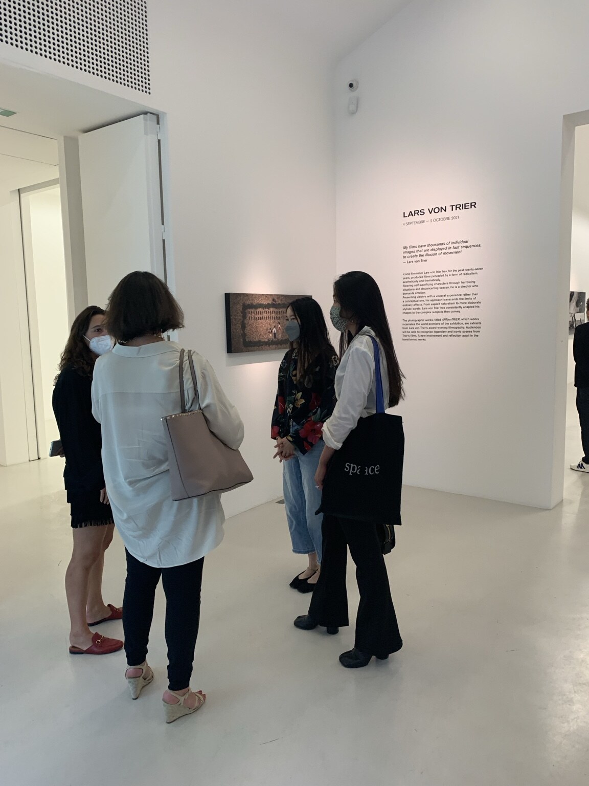 Visitors reading the Lars von Trier exhibition wall text